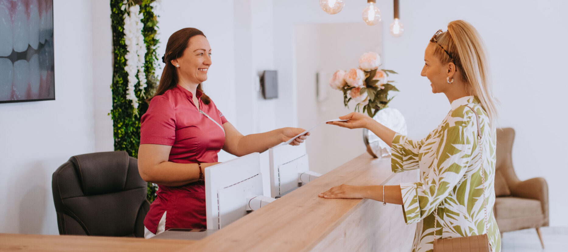 Beautiful blonde shakes hands with an emplaoyee of the dental office after the agreed dental examination.